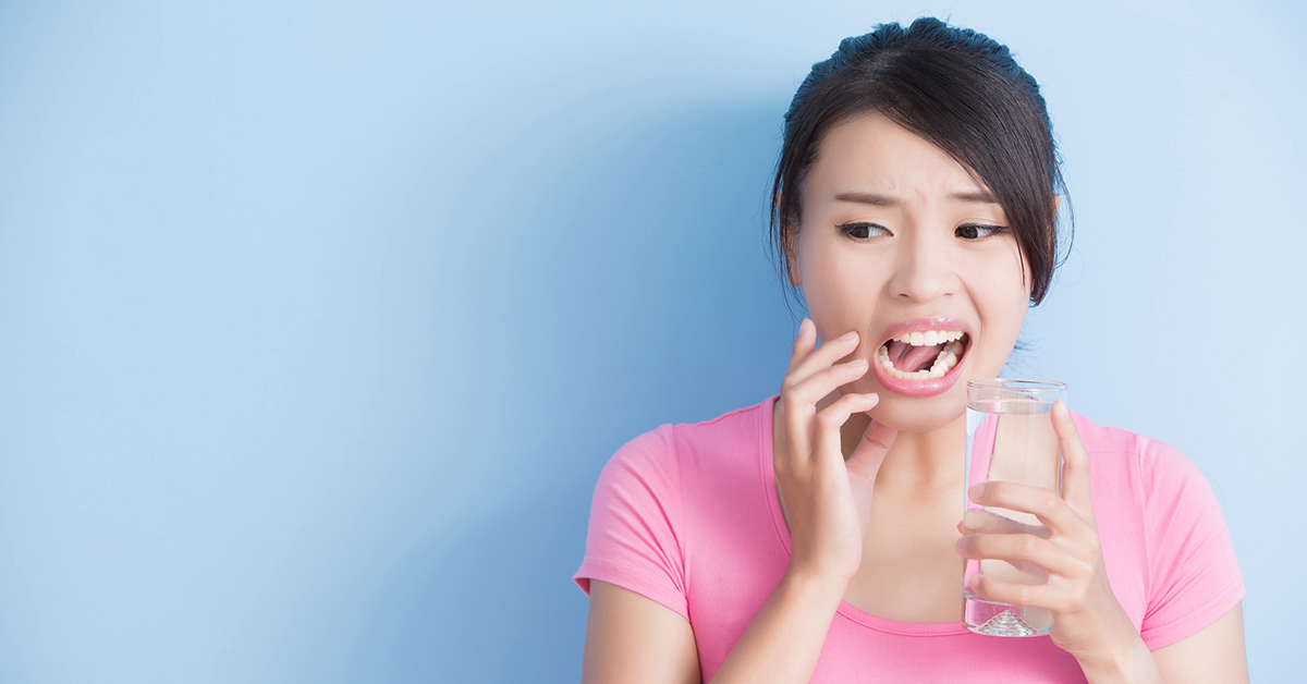 Woman having teeth sensitivity